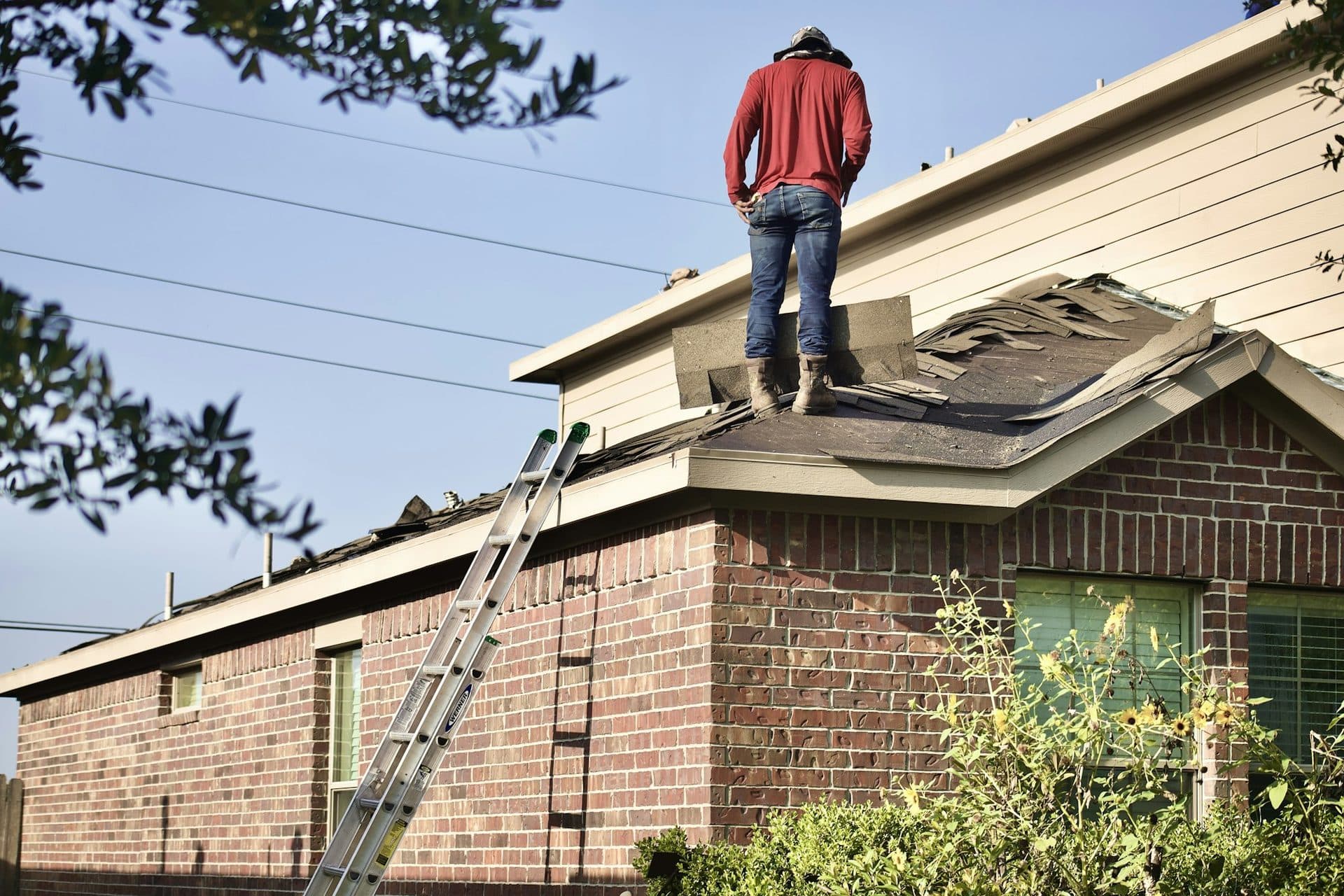 A roofer standing on a residential roof