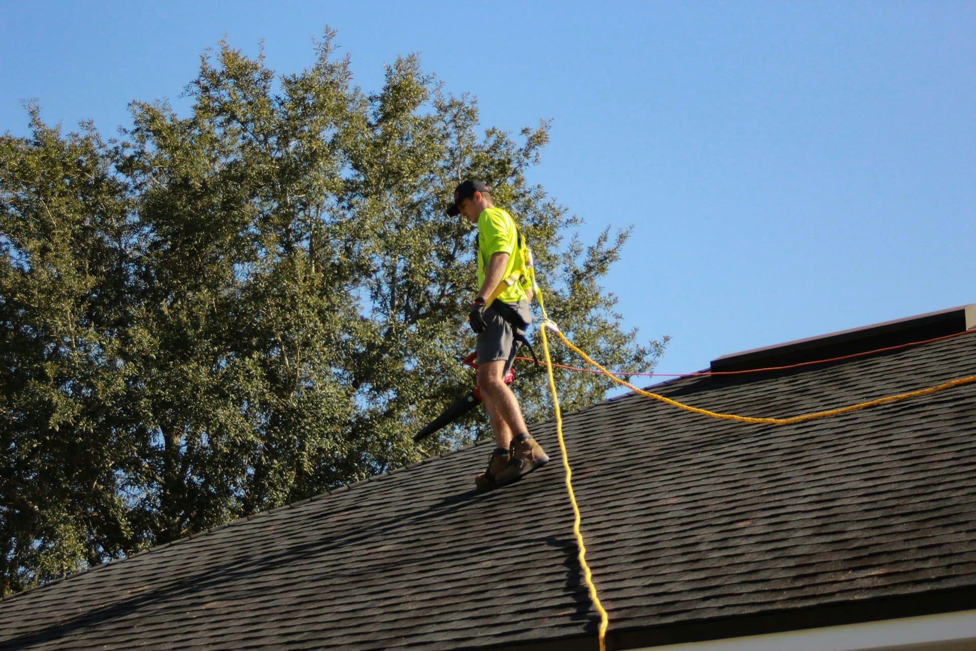A roofer working on a steep-slope shingle roof